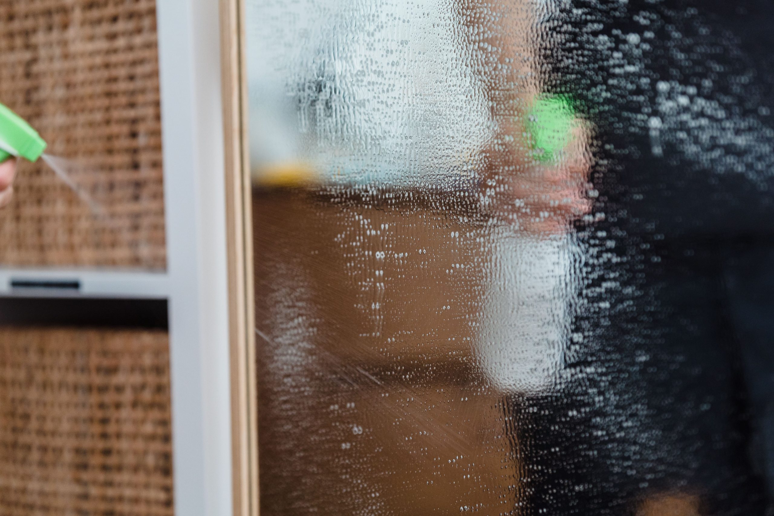 Nettoyage d'un miroir avec un vaporisateur