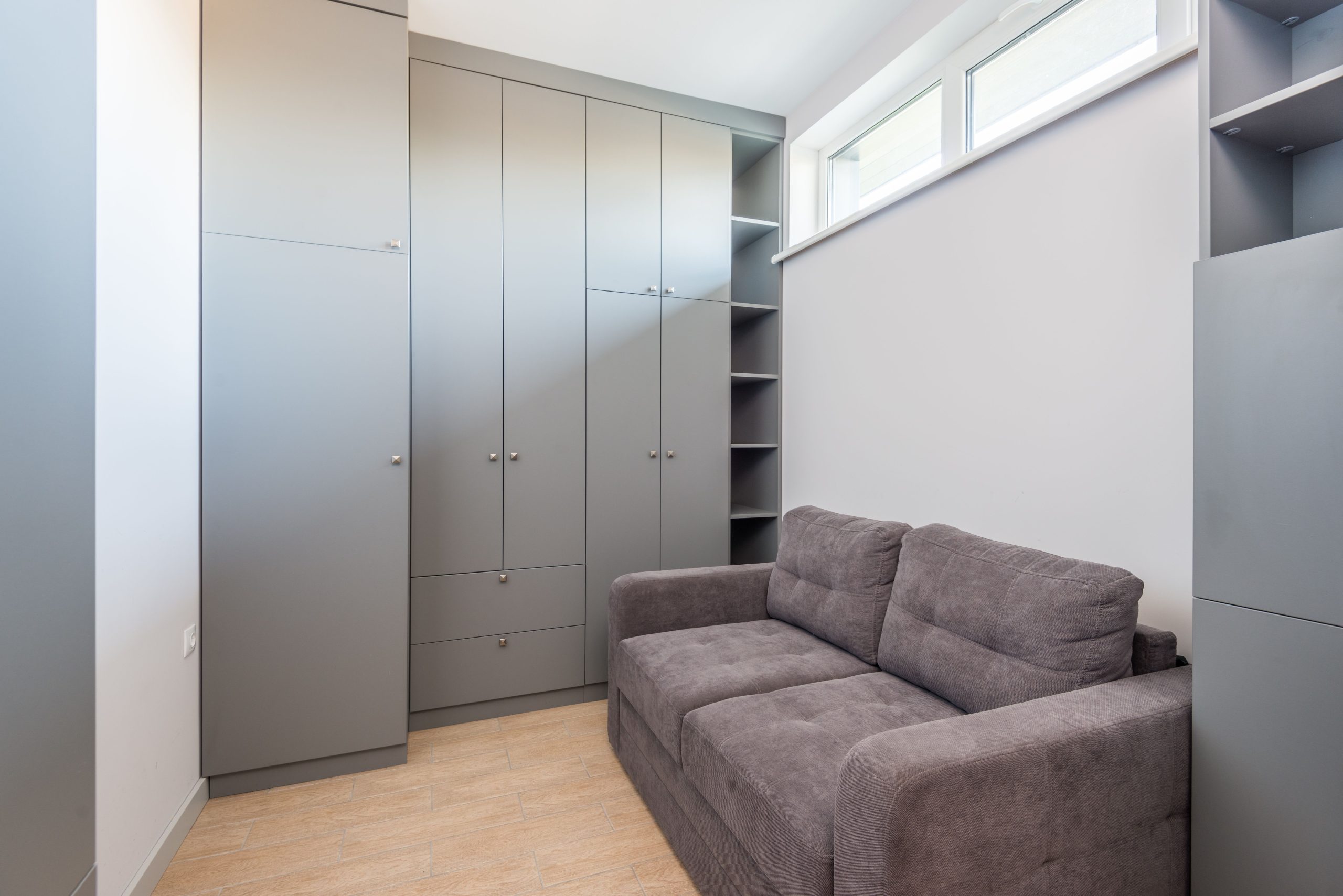 Appartement moderne avec armoire grise optimisant l'espace