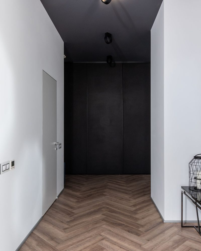 Couloir étroit avec portes blanches et décoration créative
