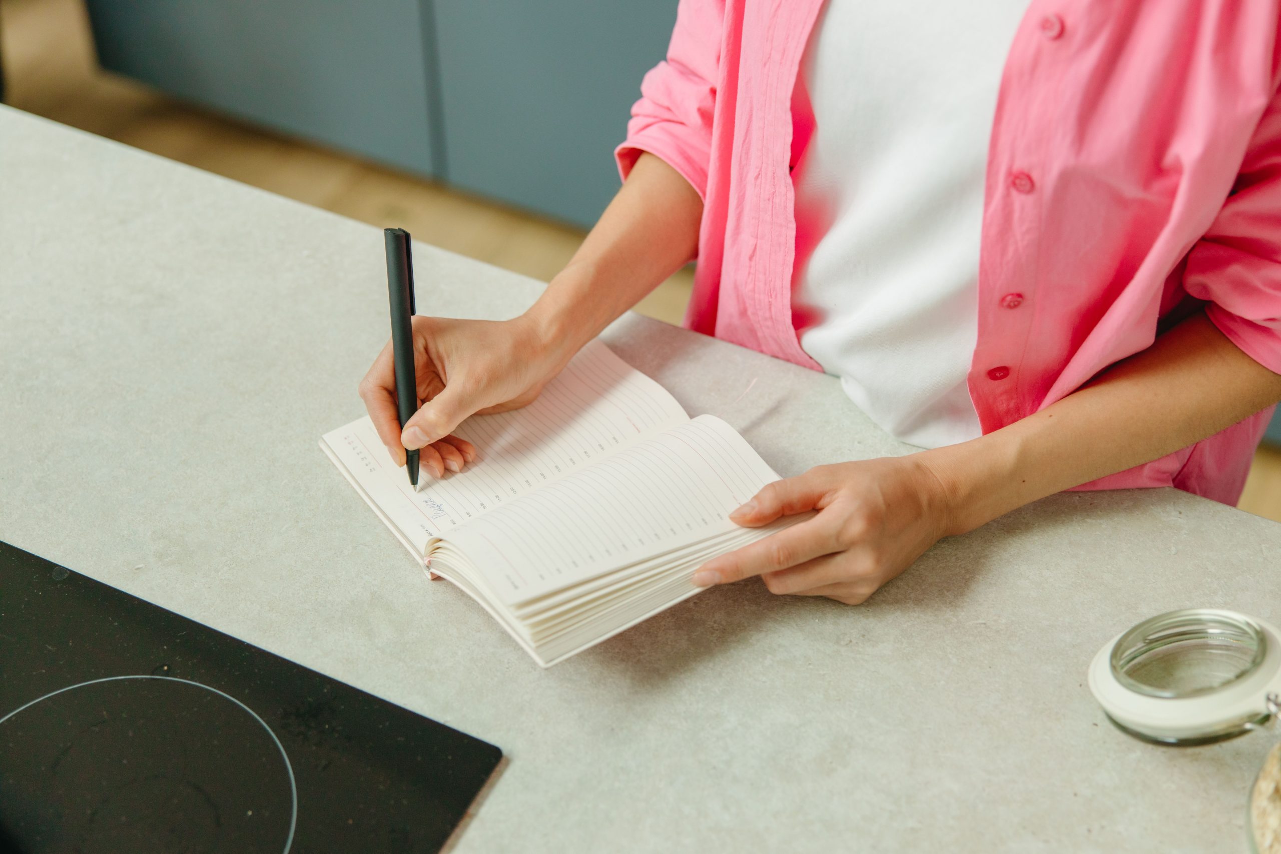 Femme écrivant sa liste courses en cuisine