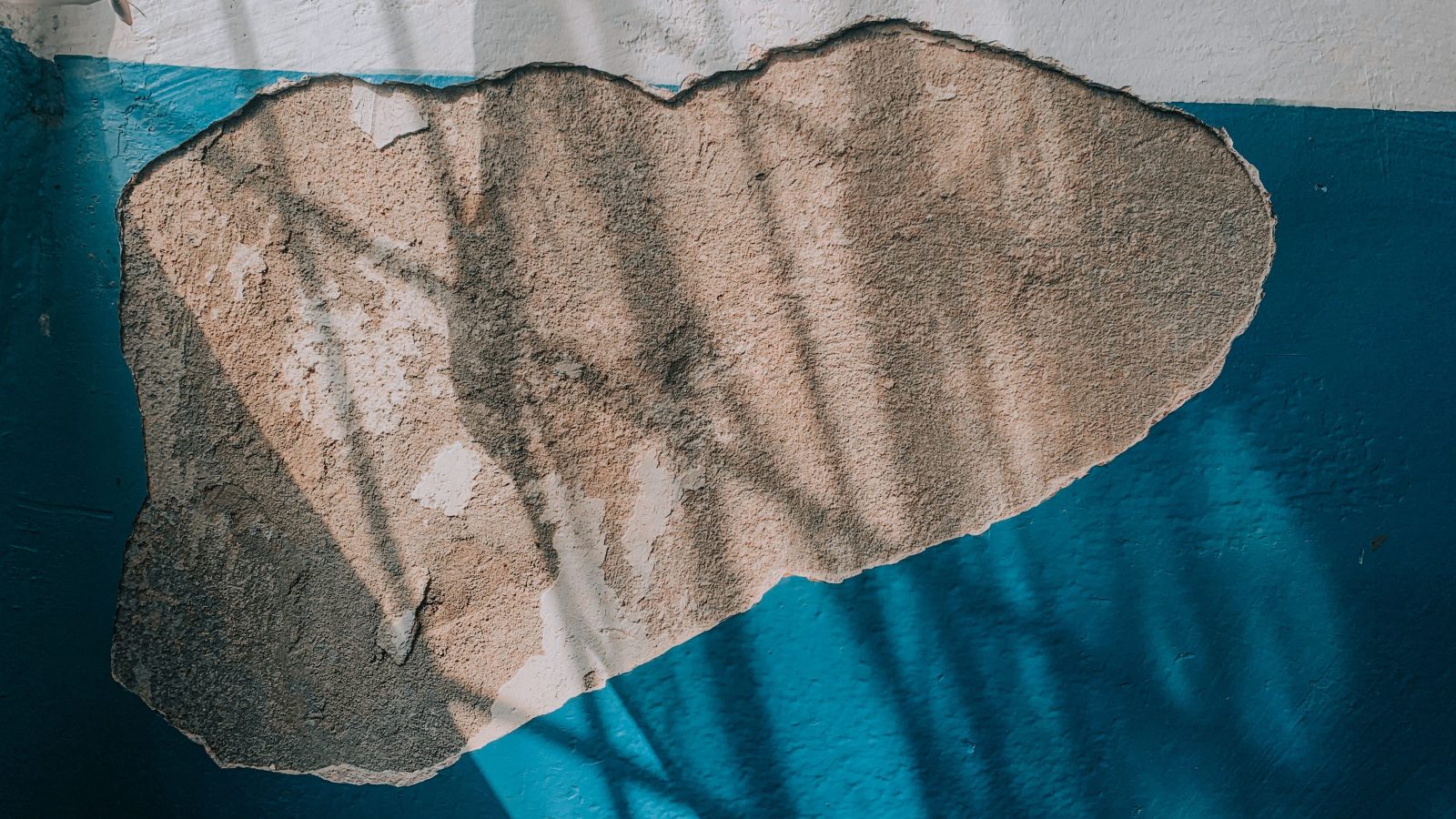 Peinture bleue écaillée sur un mur humide