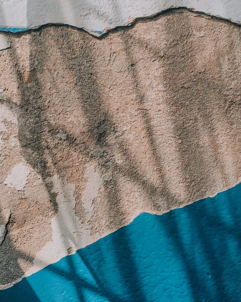 Peinture bleue écaillée sur un mur humide