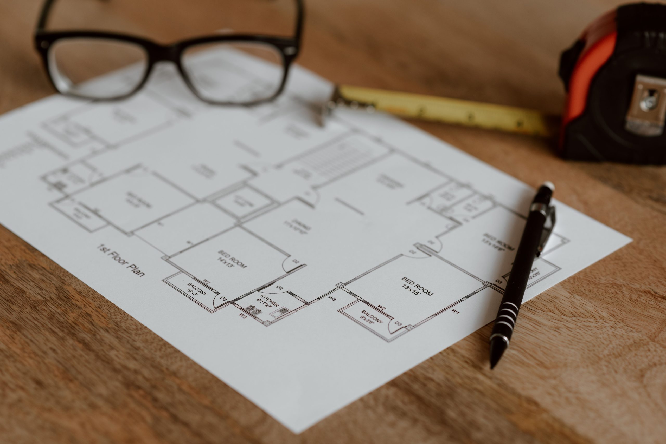 Règle crayon lunettes sur plan construction maison
