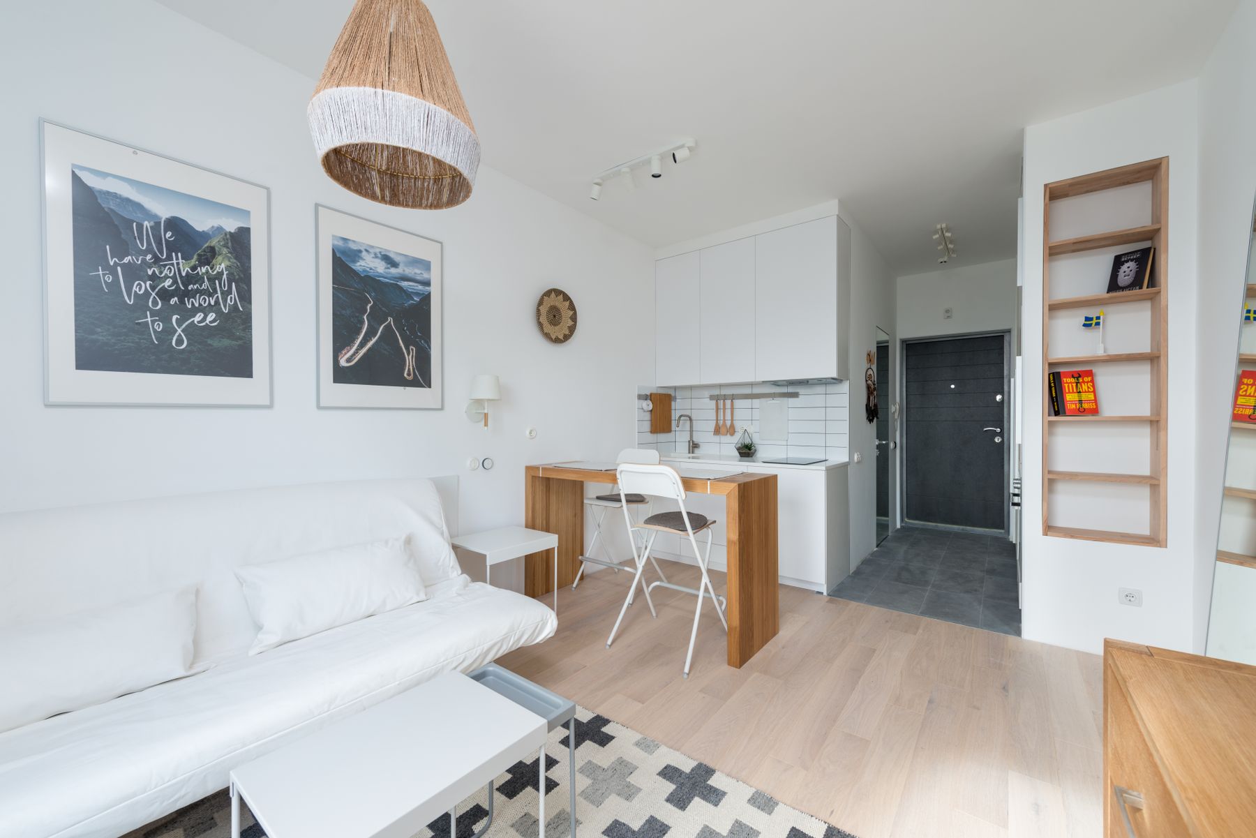 Petit salon blanc lumineux avec mobilier en bois clair et rangements