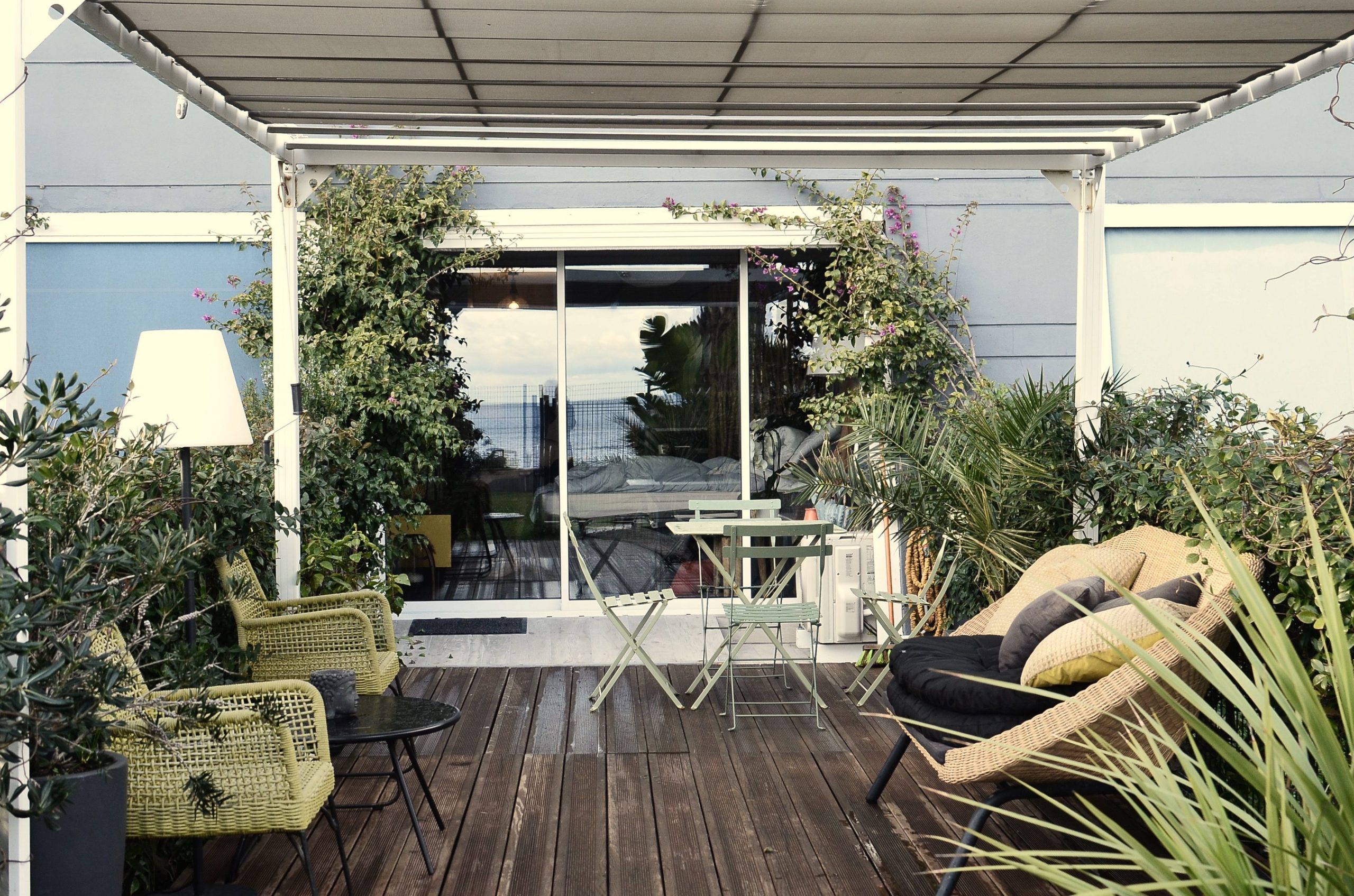Fauteuils rattan stylés sur terrasse moderne.